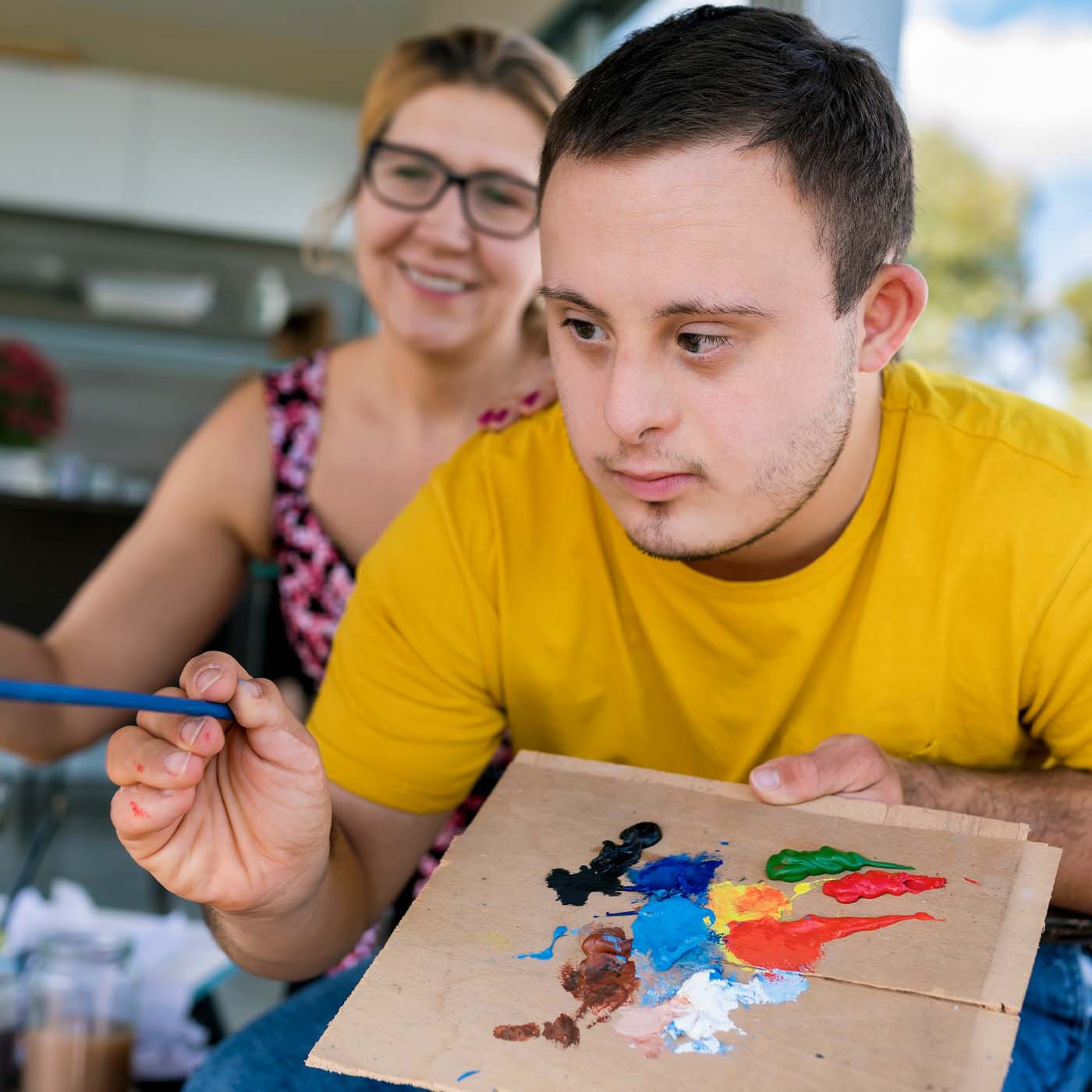 teenage boy with down syndrome painting